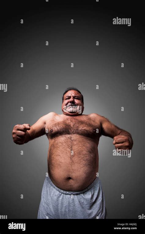 The Strong And Fat Man Showing His Muscles And Belly Stock Photo Alamy