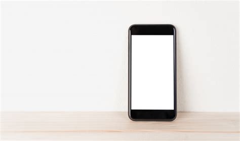 Premium Photo White Screen Phone Rests Against The Wall