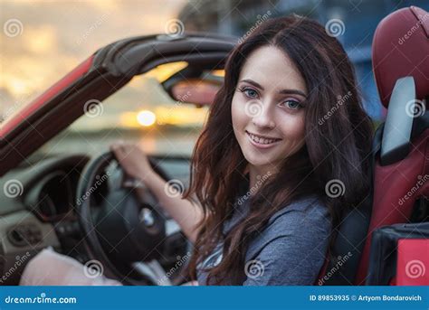 Pretty Young Brunette Woman Driving Luxury Red Cabriolet Car At The