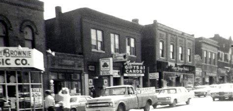 An Old Black And White Photo Of Cars Parked On The Side Of The Road In