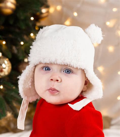 Christmas Baby Looking At The Camera A Cute Little Girl In A Red Dress