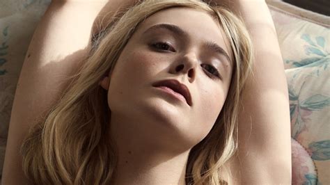 Mary Elle Fanning Is Lying On A Couch And Holding Her Hands Up Hd Mary