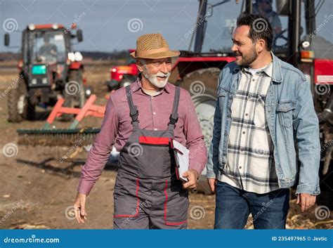 Two Farmers Talking In Field With Tractors In Background Stock Image Image Of Agribusiness