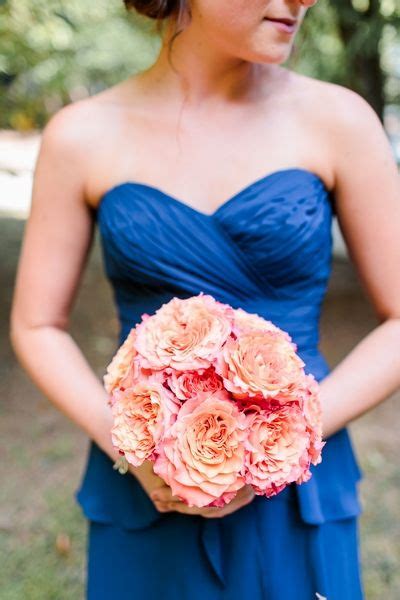 Royal Blue Wearing Bridesmaid Showing Off Peach And Pink Bouquet