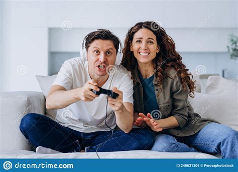 Young Woman Supports Husband Playing Games With Controller Stock Image