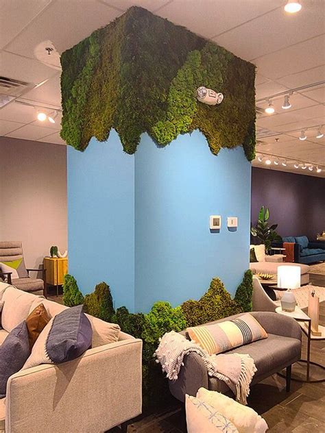 A Living Room With Couches Chairs And Moss Covered Wall In The Middle