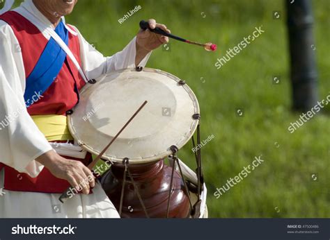 A Cropped Side View Of A Korean Drummer Playing The Traditional Hourglass Shaped Drum Janggu