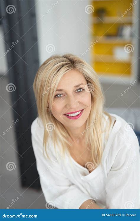 Glimlachende Blonde Volwassen Vrouw Die De Camera Bekijken Stock