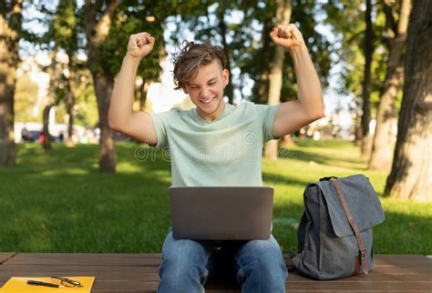 Excited Student Guy With Laptop Computer Gesturing Yes And Celebrating