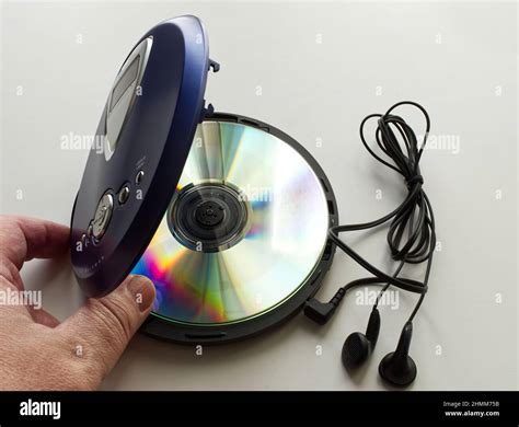 Hand Opening A Vintage Cd Walkman With Headphones On White Background