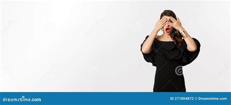 Fashion And Beauty Image Of Shocked Glamour Woman In Black Dress Covering Eyes But Peeking