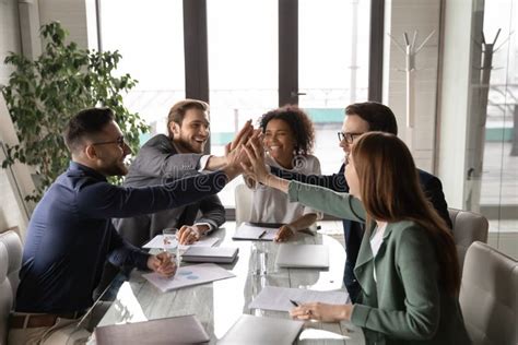 Excited Diverse Business Team Giving High Five At Briefing Stock Image