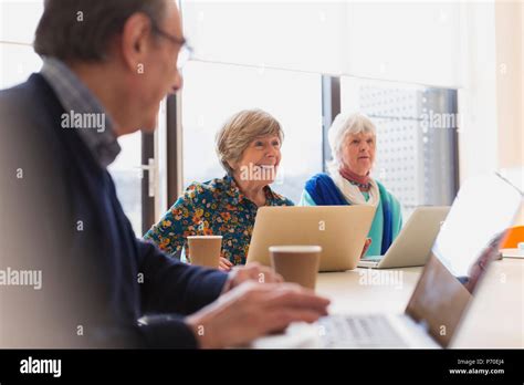 Senior Businesswomen Using Laptops In Conference Room Meeting Stock