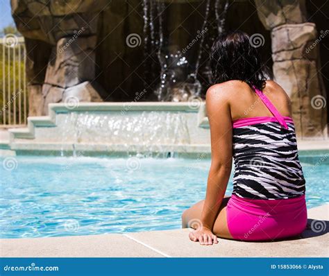 beautiful girl poolside relaxing by a waterfall royalty free stock image