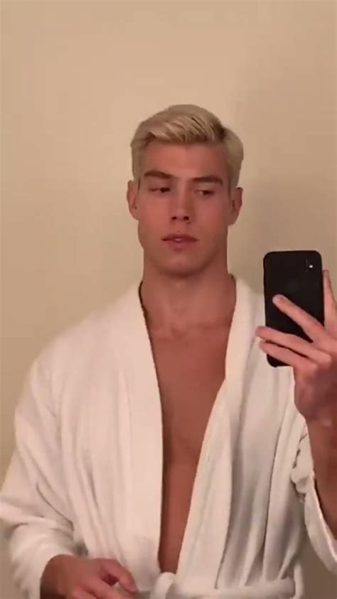 A Man Is Taking A Selfie With His Cell Phone While Wearing A Bathrobe