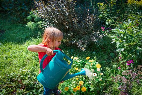 Kid Watering Flowers In Garden People Images ~ Creative Market