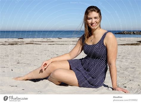 Junge Große Frau Sitzt Im Sommerkleid Am Ostseestrand Und Lächelt
