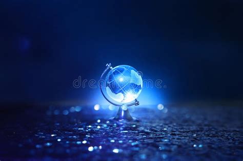 Small Crystal Globe In Front Of Dark And Dramatic Lightglobal Issues