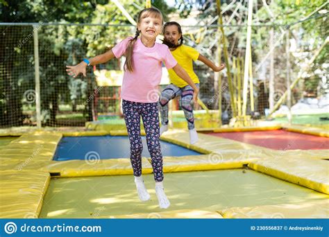 Two Girls Jumping On A Trampoline On A Summer Day Stock Image Image