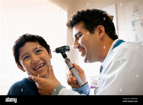 Doctor Examining His Young Patients Ear With Otoscope Stock Photo Alamy