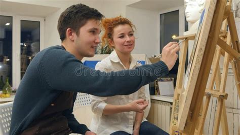 Female Artist Teaching Young Student To Paint With Watercolor Stock