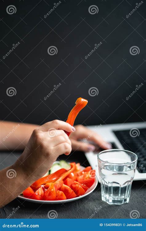 Mujer Snacking Con Las Verduras Cortadas En El Lugar De Trabajo Imagen