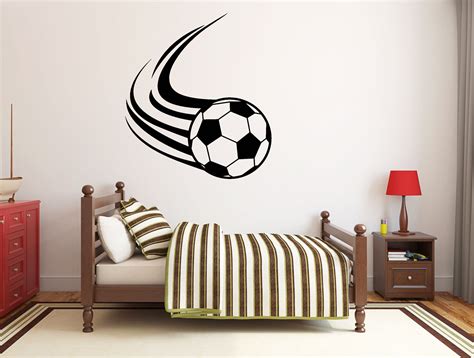 A Bedroom With A Soccer Ball Wall Decal On The Wall And A Bed In Front