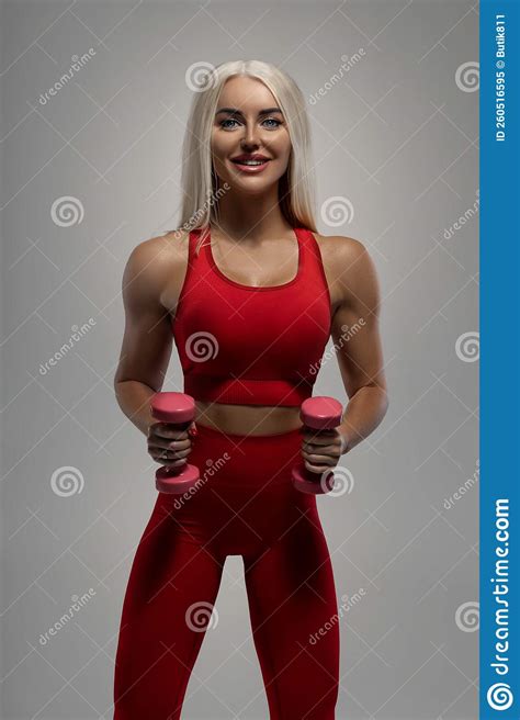 fit blonde model in red sportswear posing with small pink dumbbells stock image image of