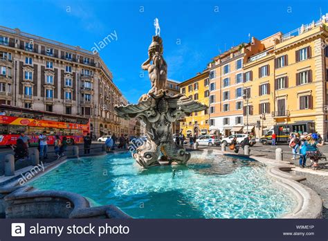 Tourists And Locals Visit The Triton Fountain In The Piazza Barberini