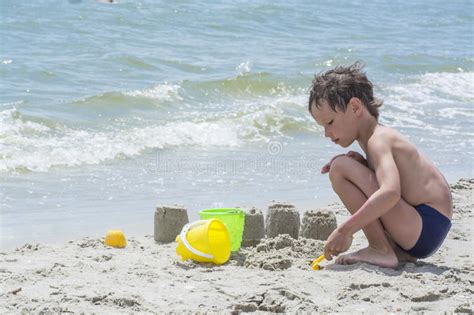 Ragazzo Che Gioca Con La Sabbia Sulla Spiaggia Torri Di Costruzione Immagine Stock Immagine