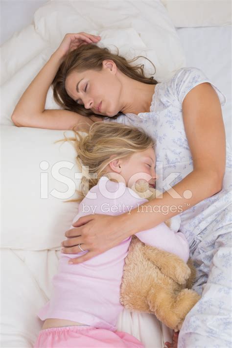 Girl And Mother Sleeping Peacefully With Stuffed Toy In Bed Stock Photo