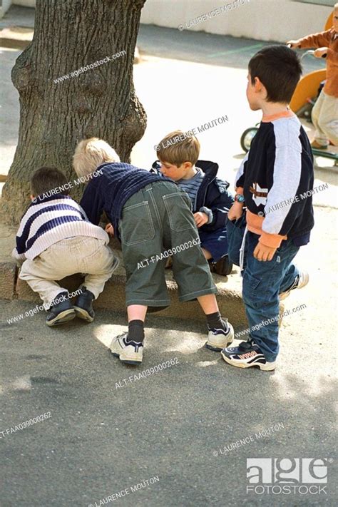 Boys Playing Beside Tree Trunk Stock Photo Picture And Royalty Free