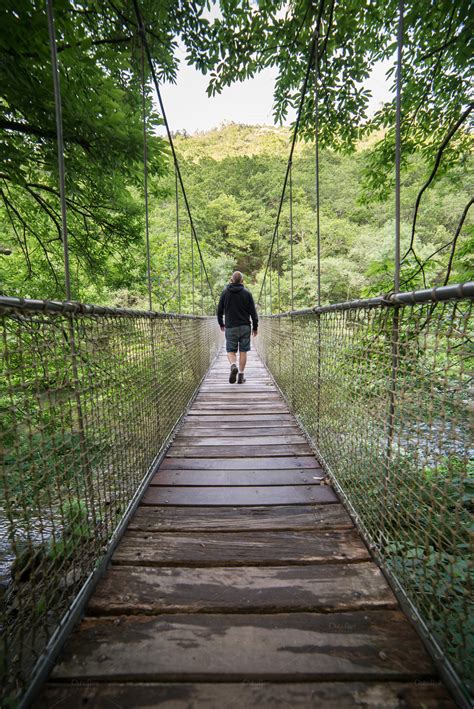 Man Crossing A Suspension Bridge ~ People Photos On Creative Market