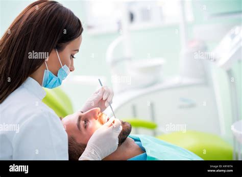 Dentist Examining A Patient S Teeth In The Dentist Stock Photo Alamy