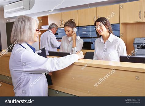 Senior Doctor Talking Receptionist Hospital Reception Stock Photo