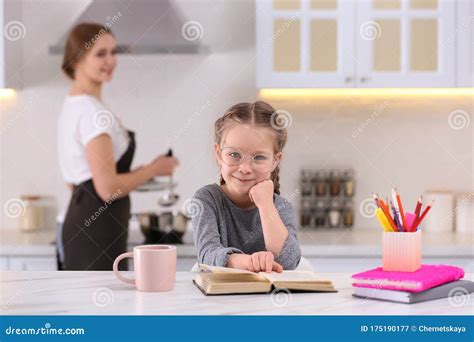 Girl Doing Homework While Mother Cooking In Kitchen Stock Image Image Of Daughter Kitchen