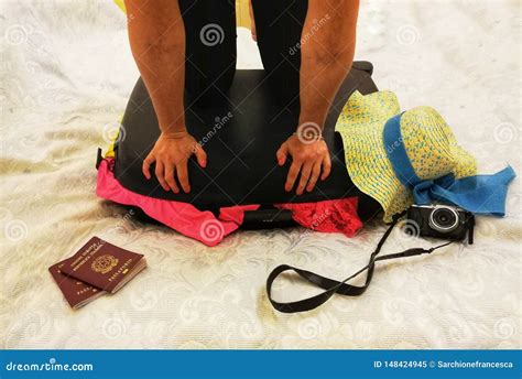 woman tries to close the full suitcase stock image image of lowsection passports 148424945