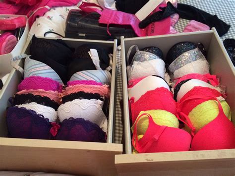 Several Pairs Of Bras Are In Boxes On A Bed With Pink And White Sheets