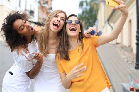 Three Cute Young Girls Friends Having Fun Together Taking A Selfie At