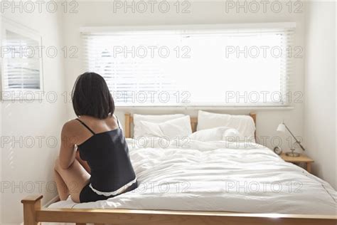 hispanic woman sitting on bed photo12 tetra images siri berting