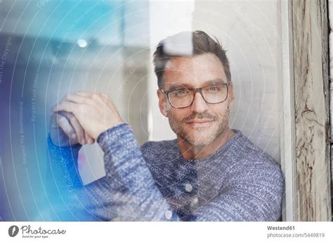 Portrait Of Man With Hands Behind Head Wearing Glasses A Royalty Free