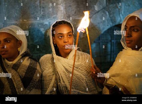 Ethiopian women share the holy fire using candles during the Holy Fire