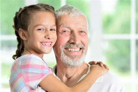 Premium Photo Grandfather With Her Granddaughter Hugging