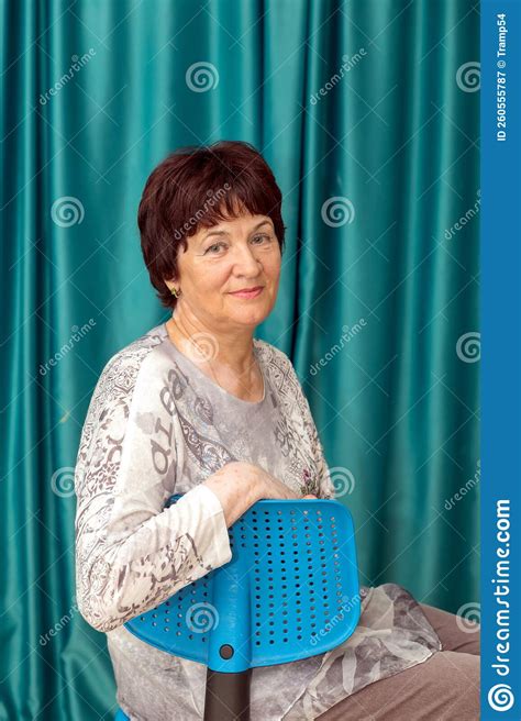 Portrait Of A Beautiful Mature Woman Sitting On A Chair Stock Image