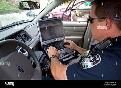 Police Officer Using A Mobile Data Terminal Computer Inside A Police Car In Boise Idaho Usa
