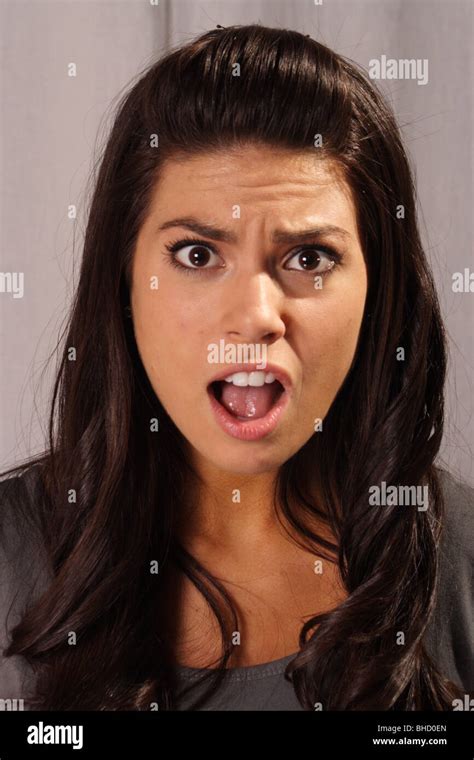 Pretty Woman With Mouth Open And Shocked Expression Looking Into Camera