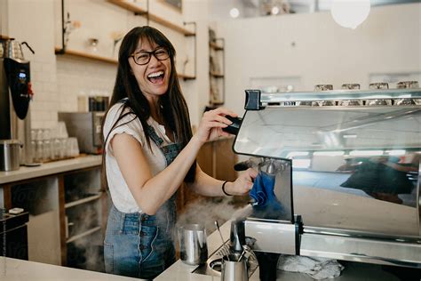 Female Barista Steaming Milk In Coffee Shop By Stocksy Contributor