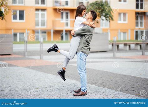 Cute Girl Jumping To Man Sunny Summer Day Stylish Couple In Love Hugging And Kissing In City