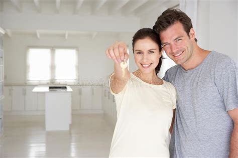 couple holding keys in new home smiling at camera ad keys holding couple camera