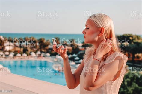 Attractive Young Woman With Blonde Hair Checking Her Make Up Looking At